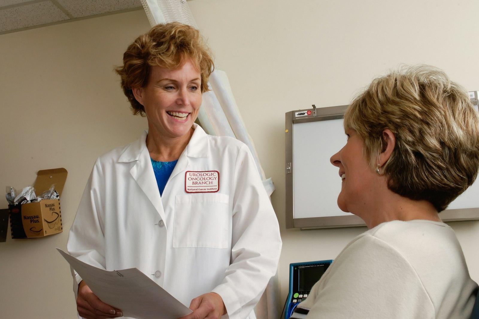 Senior compliance director reviewing customized safety binders with a practice manager in Clinical Laboratories & Physician Offices